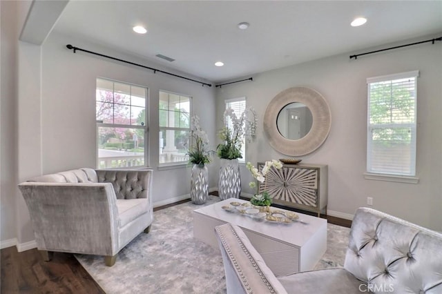 living area featuring plenty of natural light, baseboards, recessed lighting, and wood finished floors