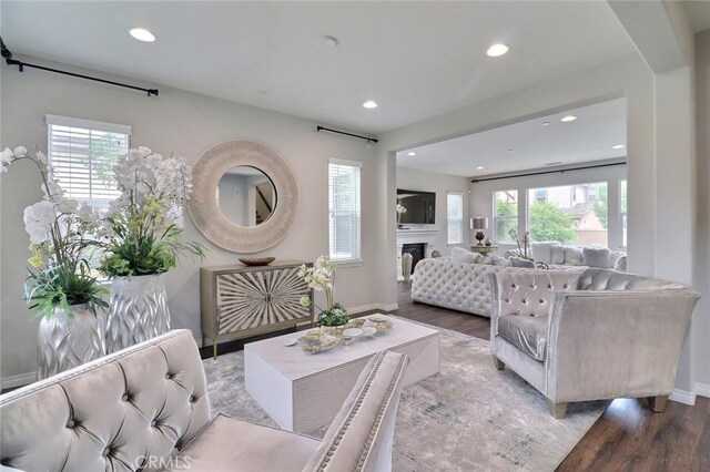 living room with wood finished floors, recessed lighting, baseboards, and a fireplace