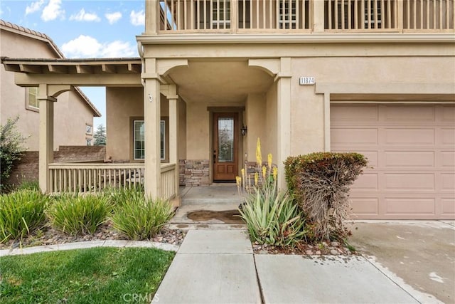 11874 Grayhawk Cir, Yucaipa, CA 92399 - doorway to property featuring stucco siding, a balcony, covered porch, and an attached garage