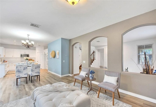 37089 Meadow Brook Way, Beaumont, CA 92223 - living area with light wood-style flooring, arched walkways, baseboards, a chandelier, and recessed lighting