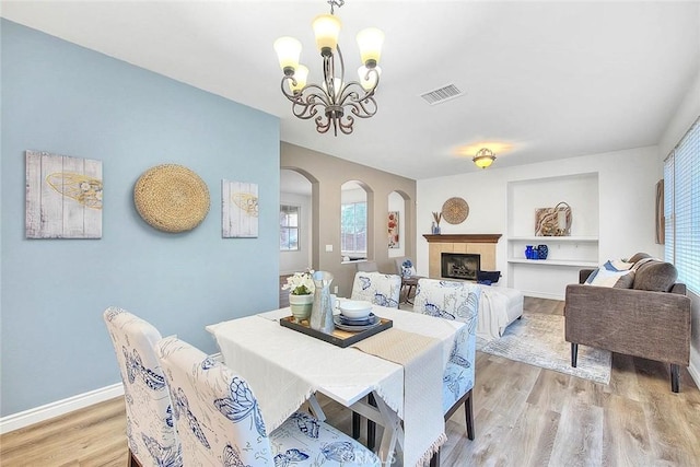 37089 Meadow Brook Way, Beaumont, CA 92223 - dining room featuring a chandelier, healthy amount of natural light, arched walkways, and light wood-style flooring