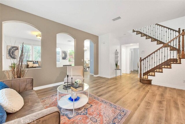 37089 Meadow Brook Way, Beaumont, CA 92223 - living area featuring arched walkways, wood finished floors, stairs, and baseboards
