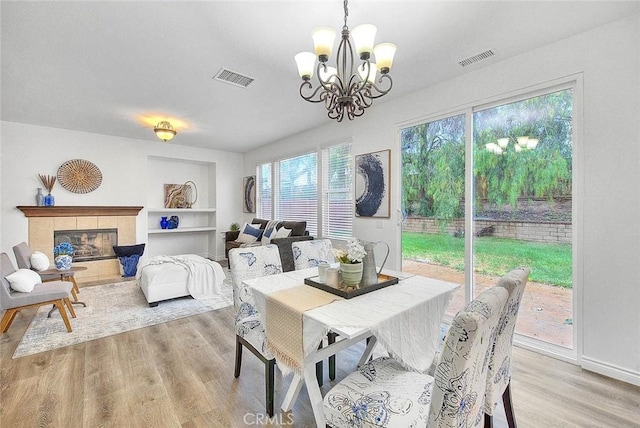 37089 Meadow Brook Way, Beaumont, CA 92223 - dining room featuring a chandelier, light wood finished floors, and a tile fireplace