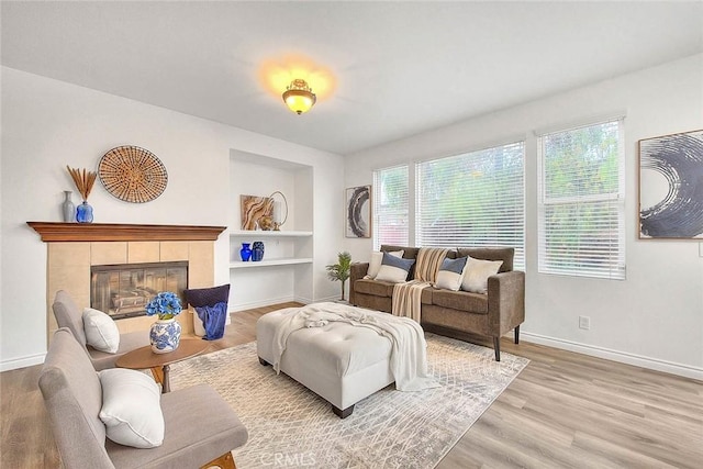 37089 Meadow Brook Way, Beaumont, CA 92223 - living area with baseboards, built in shelves, light wood-type flooring, and a tiled fireplace
