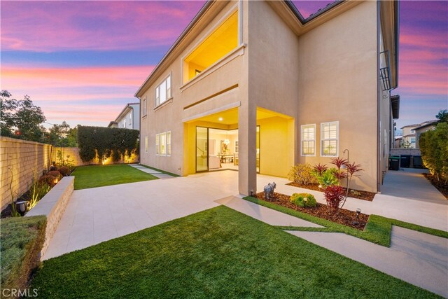 rear view of property featuring stucco siding and a patio area