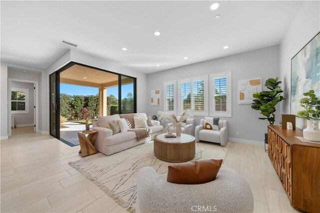 living room featuring plenty of natural light, recessed lighting, and baseboards