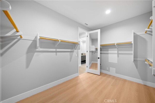 walk in closet with wood finished floors