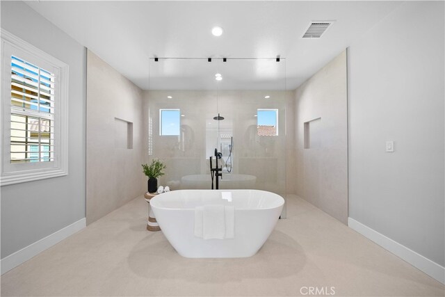 bathroom with a soaking tub, walk in shower, baseboards, and recessed lighting