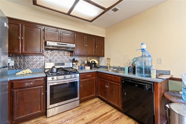 1451 Segovia Ct, Madera, CA 93638 - kitchen with stainless steel appliances, a sink, under cabinet range hood, light wood-style floors, and decorative backsplash