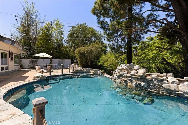 view of pool featuring a patio area, a fenced backyard, and a pool with connected hot tub