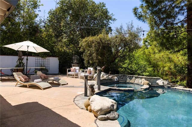 view of swimming pool featuring a patio and a pool with connected hot tub