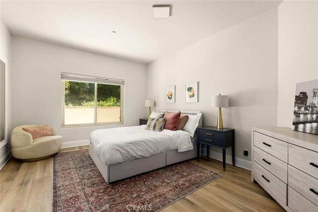 bedroom featuring light wood-type flooring and baseboards
