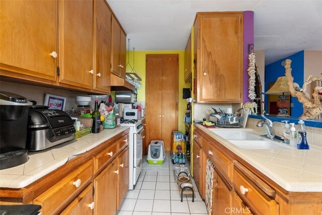 2785 Solana Way, Laguna Beach, CA 92651 - kitchen with exhaust hood, white gas range oven, light tile patterned floors, and tile counters