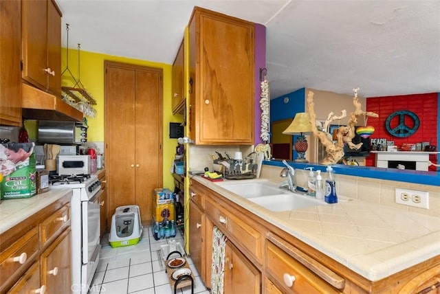 2785 Solana Way, Laguna Beach, CA 92651 - kitchen featuring white gas stove, light tile patterned floors, brown cabinetry, and a sink