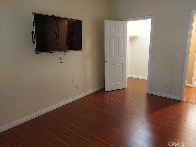 unfurnished bedroom featuring wood finished floors and baseboards