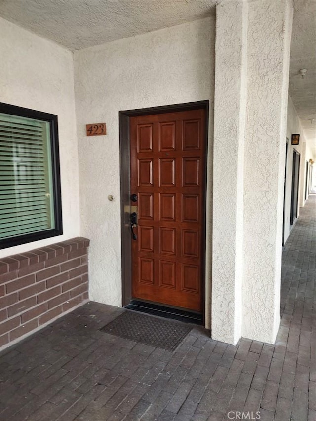 view of exterior entry with stucco siding