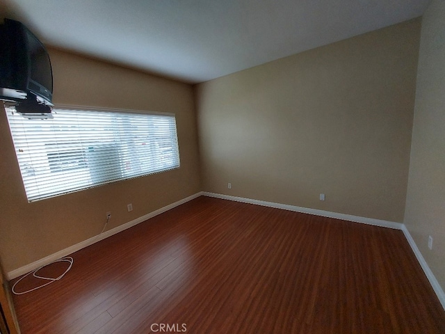 empty room with wood finished floors and baseboards