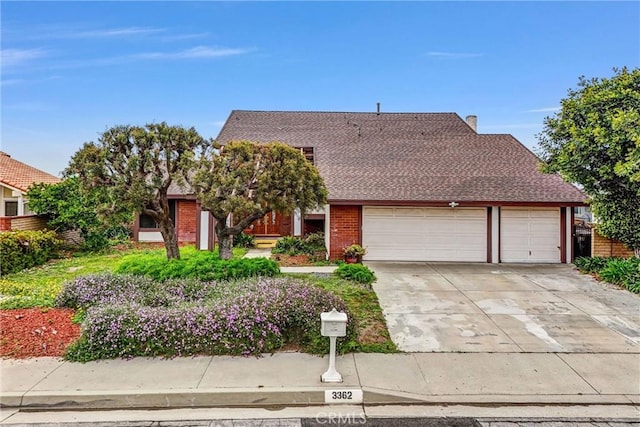 view of front facade featuring an attached garage, concrete driveway, brick siding, and roof with shingles