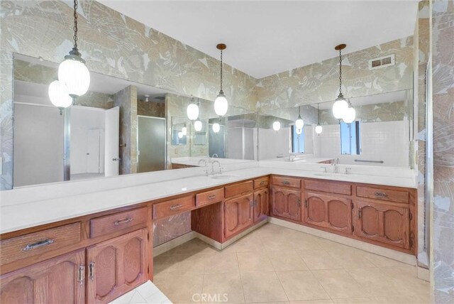 bathroom featuring tile patterned floors, double vanity, and a shower with door