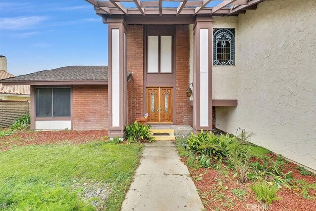 entrance to property with brick siding and stucco siding