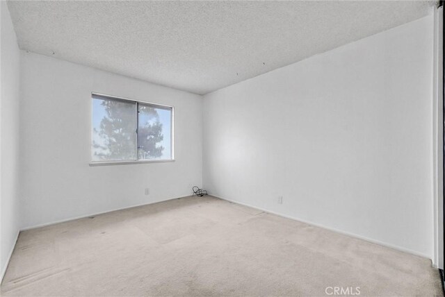 empty room featuring carpet floors and a textured ceiling