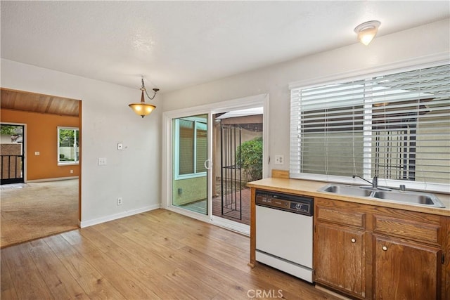 22951 Caminito Viento, Laguna Hills, CA 92653 - kitchen with white dishwasher, light wood-style floors, a sink, baseboards, and light countertops