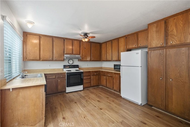 22951 Caminito Viento, Laguna Hills, CA 92653 - kitchen with freestanding refrigerator, electric stove, under cabinet range hood, and brown cabinetry