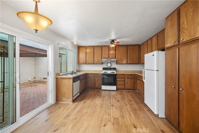 22951 Caminito Viento, Laguna Hills, CA 92653 - kitchen featuring freestanding refrigerator, electric range, brown cabinetry, and under cabinet range hood