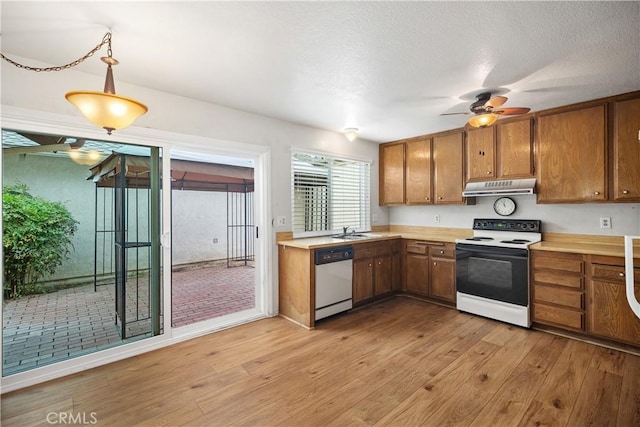 22951 Caminito Viento, Laguna Hills, CA 92653 - kitchen featuring electric stove, dishwashing machine, under cabinet range hood, light countertops, and a sink
