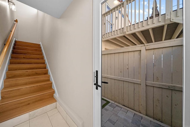 stairway featuring baseboards and tile patterned floors