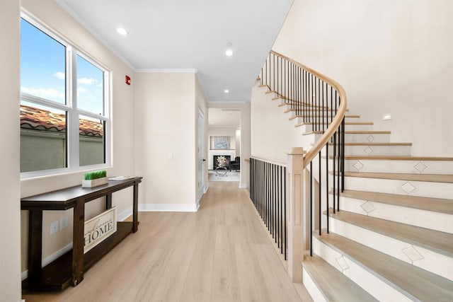 hall with wood finished floors, stairs, ornamental molding, baseboards, and recessed lighting