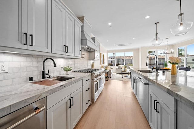 kitchen featuring a sink, appliances with stainless steel finishes, backsplash, recessed lighting, and light stone counters