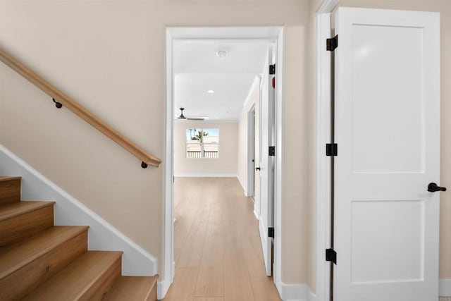 hall featuring stairway, light wood-style flooring, baseboards, and recessed lighting