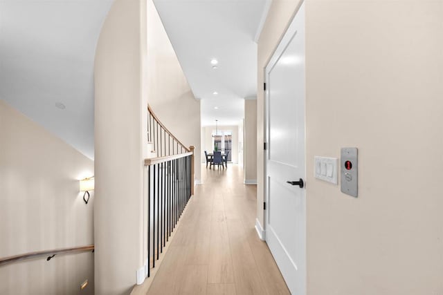 hall featuring light wood finished floors, recessed lighting, a chandelier, and baseboards