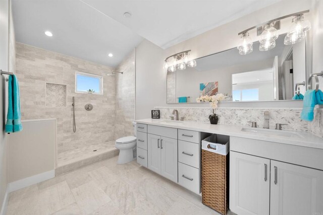 bathroom featuring a walk in shower, double vanity, toilet, tasteful backsplash, and recessed lighting