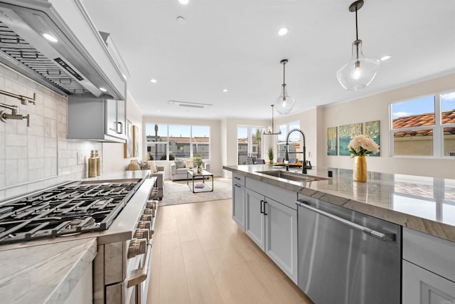 kitchen featuring stainless steel appliances, a sink, custom range hood, healthy amount of natural light, and recessed lighting
