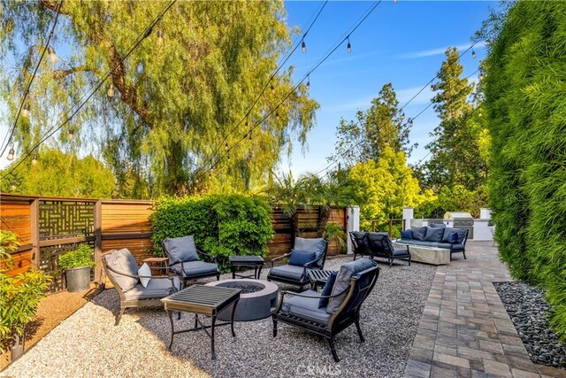 view of patio featuring an outdoor living space with a fire pit, area for grilling, and fence