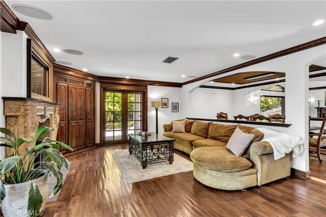 living area featuring dark wood-style floors, arched walkways, crown molding, recessed lighting, and french doors