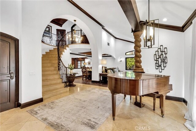 foyer featuring arched walkways, ornamental molding, stairs, a chandelier, and recessed lighting