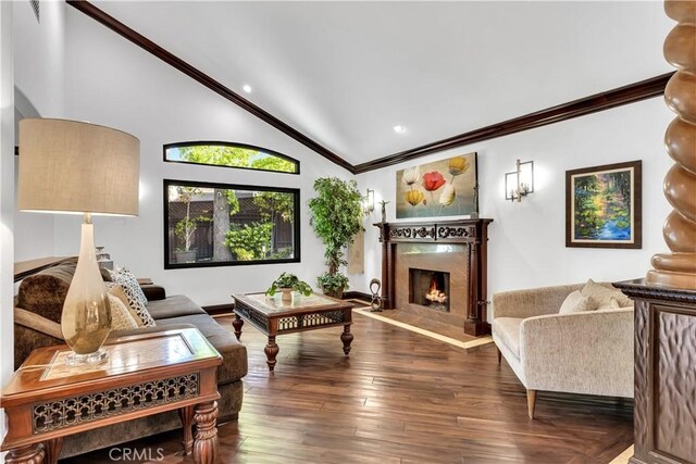 living room with vaulted ceiling, ornamental molding, a high end fireplace, recessed lighting, and wood finished floors