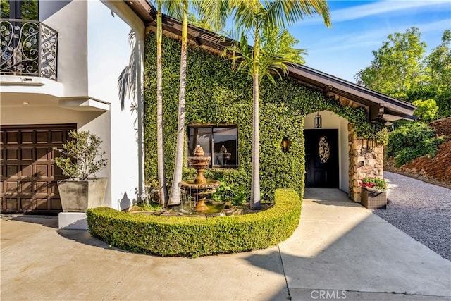 entrance to property with stucco siding and a garage