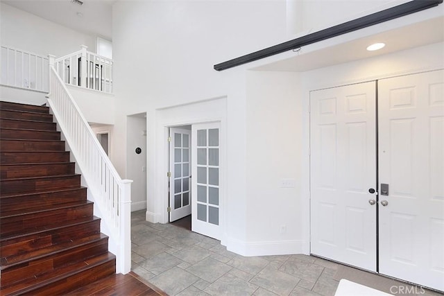entrance foyer featuring baseboards, stairs, stone finish flooring, and recessed lighting