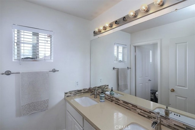 bathroom featuring toilet and double vanity