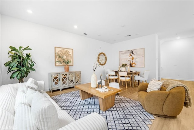 living area featuring light wood-style flooring, baseboards, and recessed lighting