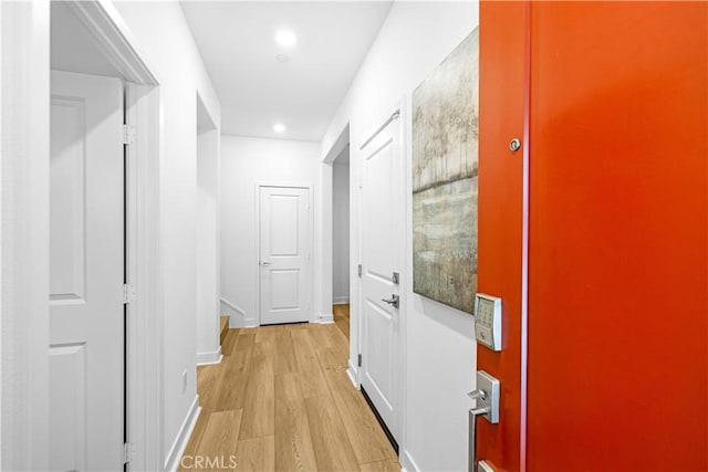 hall featuring wood finished floors, recessed lighting, and baseboards