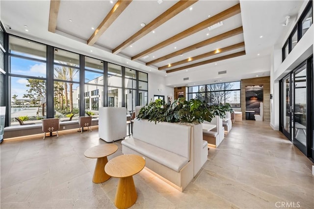 community lobby featuring a high ceiling and beamed ceiling