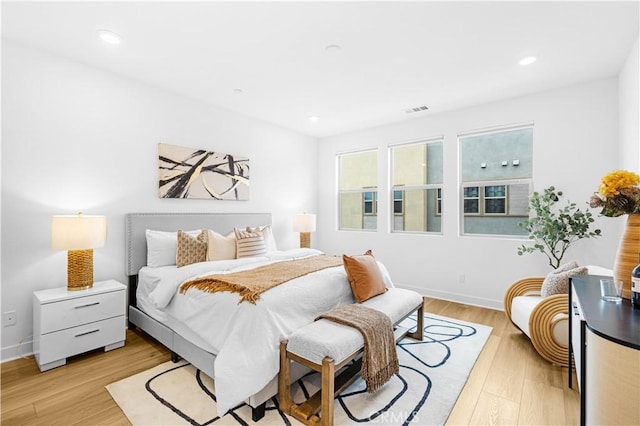 bedroom with light wood-style floors, baseboards, and recessed lighting