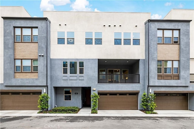 view of property with a garage and stucco siding