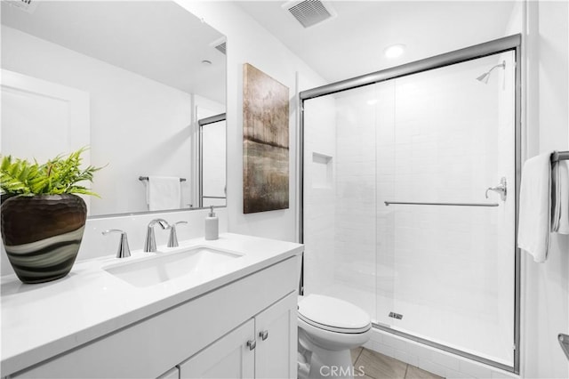 full bathroom with a stall shower, vanity, and toilet