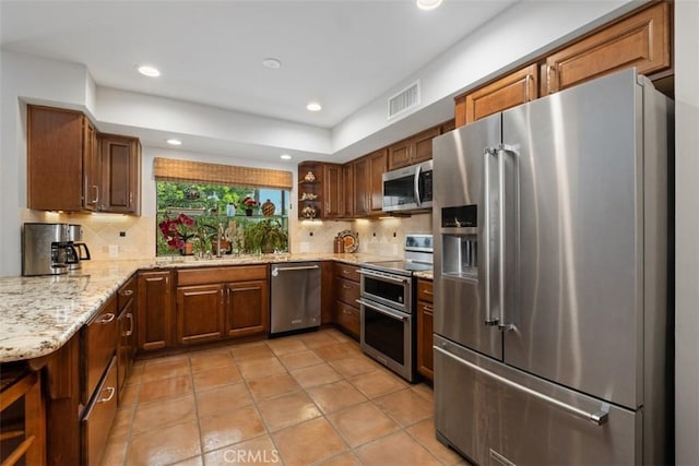 14321 Mimosa Ln, Tustin, CA 92780 - kitchen with stainless steel appliances, backsplash, light stone countertops, recessed lighting, and light tile patterned floors